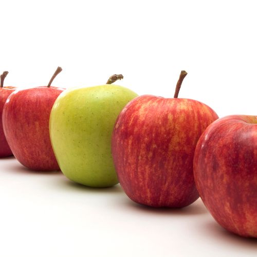 row of red apples and one green apple